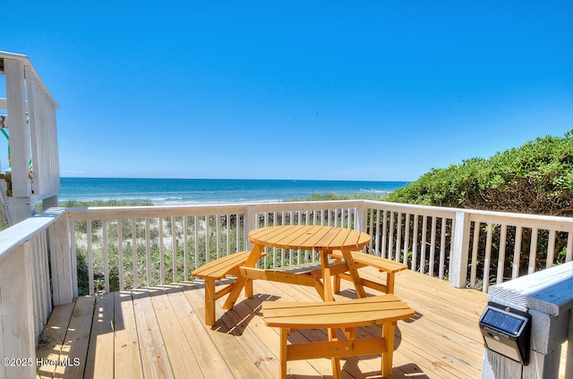 wooden terrace featuring a water view and a beach view