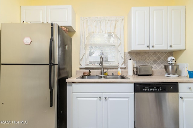 kitchen featuring stainless steel appliances, sink, white cabinets, and backsplash