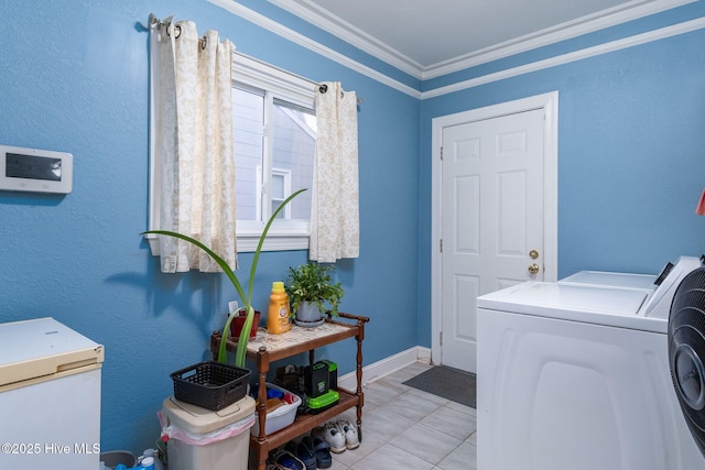 clothes washing area with light tile patterned floors, ornamental molding, and washing machine and dryer