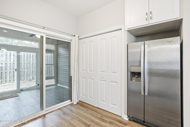 1180 Red Bay Pl, Leland, NC 28451 - kitchen with a healthy amount of sunlight, light wood finished floors, stainless steel refrigerator with ice dispenser, and white cabinetry