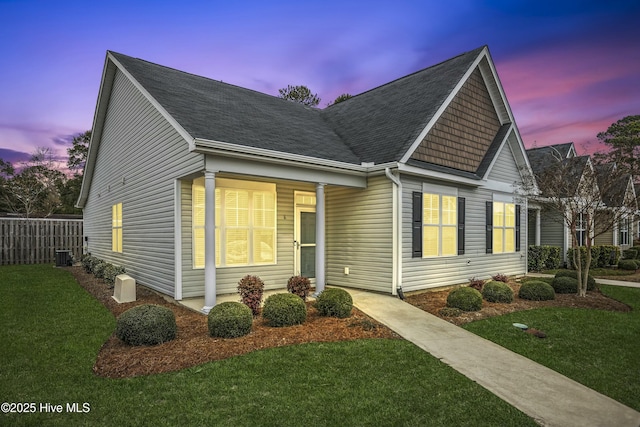 view of front of property with a yard and central AC unit