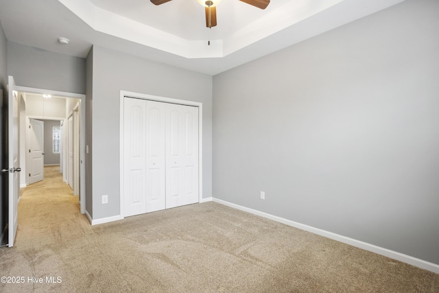 1180 Red Bay Pl, Leland, NC 28451 - unfurnished bedroom with a ceiling fan, light colored carpet, baseboards, a raised ceiling, and a closet