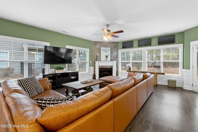 living room with a premium fireplace, dark hardwood / wood-style floors, and ceiling fan