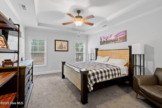 bedroom with crown molding, multiple windows, a tray ceiling, and light carpet