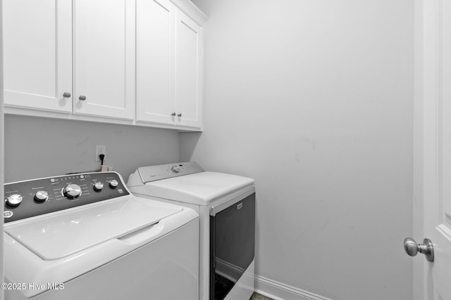 clothes washing area featuring cabinets and independent washer and dryer