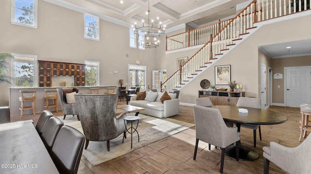 living room featuring beamed ceiling, crown molding, coffered ceiling, and light hardwood / wood-style flooring