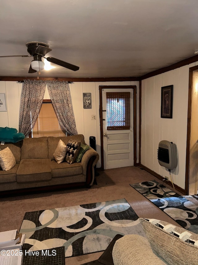 living room with heating unit, a ceiling fan, and carpet