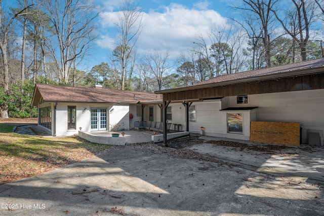 view of front of house featuring french doors, a patio area, and brick siding