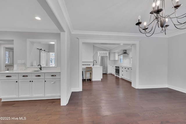 unfurnished dining area featuring dark wood-type flooring, a sink, and crown molding