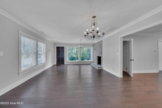 unfurnished living room with ornamental molding, dark wood-style flooring, a fireplace, and an inviting chandelier