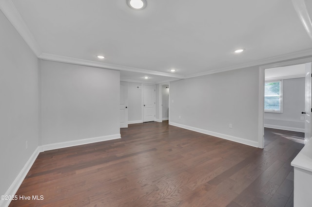 empty room featuring baseboards, ornamental molding, dark wood-type flooring, and recessed lighting