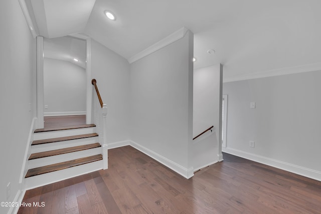 stairway with lofted ceiling, recessed lighting, wood finished floors, and baseboards