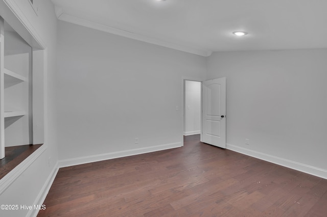 empty room with lofted ceiling, dark wood-type flooring, and baseboards