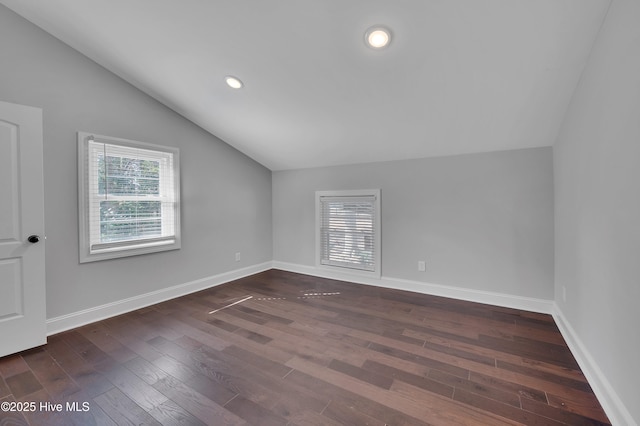 additional living space featuring dark wood-type flooring, lofted ceiling, baseboards, and recessed lighting