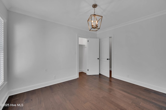 interior space featuring dark wood-style floors, a notable chandelier, baseboards, and ornamental molding