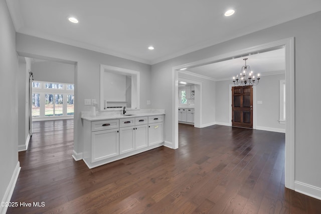 kitchen with baseboards, white cabinets, ornamental molding, dark wood-style flooring, and recessed lighting