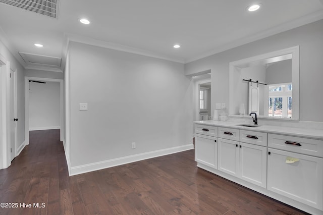 interior space with baseboards, visible vents, ornamental molding, wood finished floors, and recessed lighting