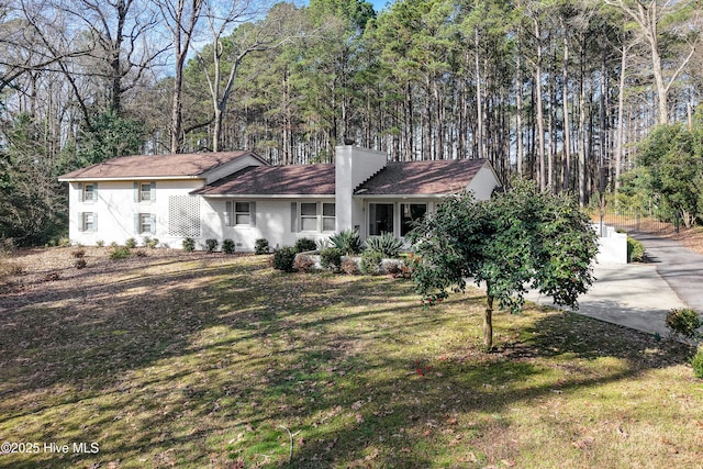 single story home with a chimney and a front yard