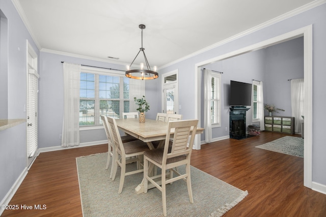 dining area featuring a fireplace with flush hearth, dark wood-style flooring, crown molding, and baseboards