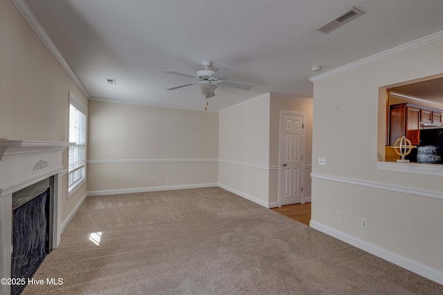 unfurnished living room featuring ceiling fan, ornamental molding, and light carpet