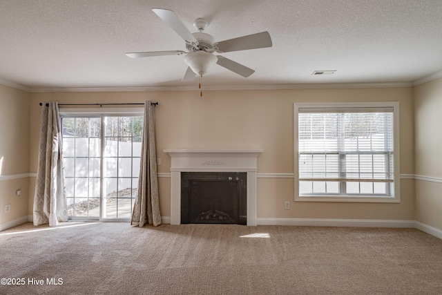 unfurnished living room featuring crown molding, carpet, ceiling fan, and a textured ceiling