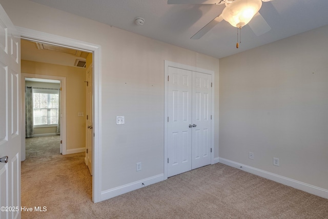 unfurnished bedroom featuring light colored carpet, a closet, and ceiling fan