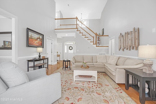 3566 Sanderling Dr SE, Southport, NC 28461 - living area featuring a high ceiling, stairway, light wood finished floors, and a chandelier