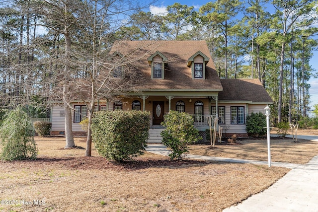 cape cod-style house featuring a shingled roof, crawl space, and a porch