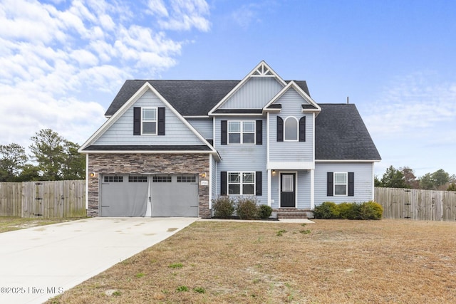 craftsman-style home featuring a front yard, concrete driveway, and fence