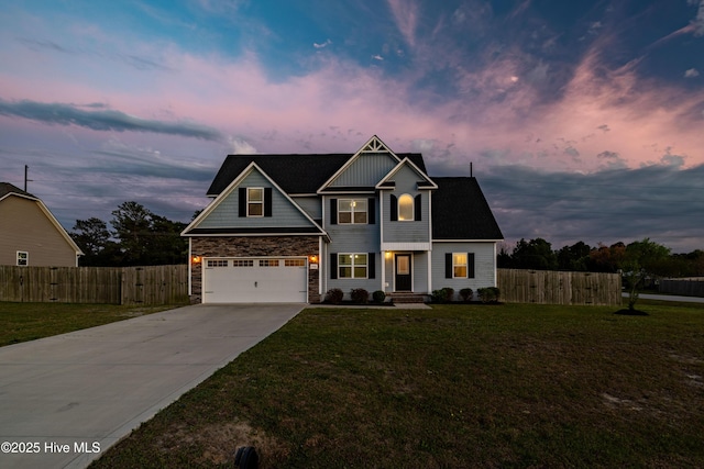 craftsman-style home featuring a yard, driveway, stone siding, and fence