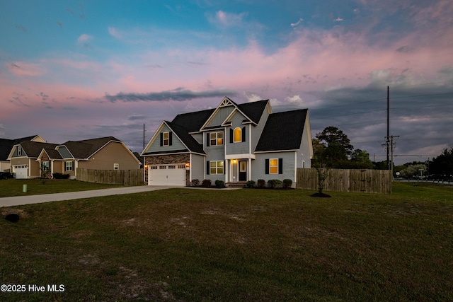 view of front facade with concrete driveway, fence, a yard, and a garage