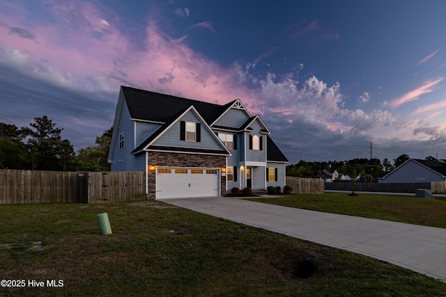 view of front of property featuring fence, a yard, concrete driveway, an attached garage, and stone siding