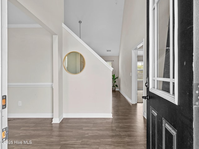 foyer with baseboards, crown molding, wood finished floors, and visible vents