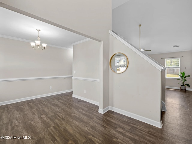 unfurnished room featuring crown molding, ceiling fan with notable chandelier, baseboards, dark wood-type flooring, and visible vents