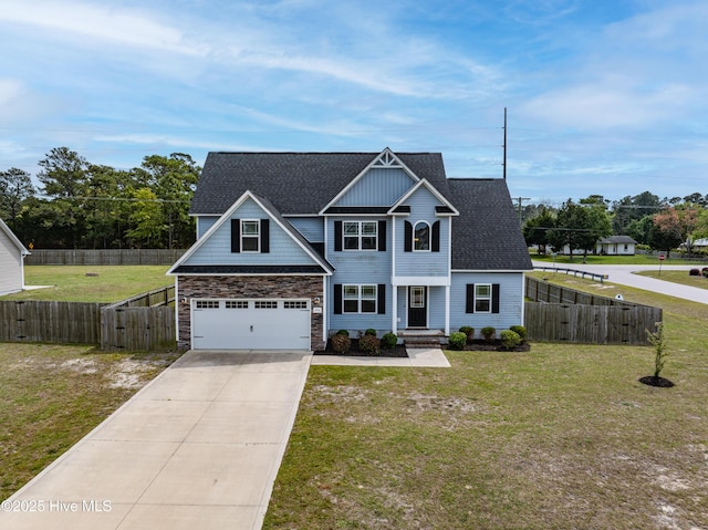 craftsman house with fence, a front lawn, driveway, and stone siding