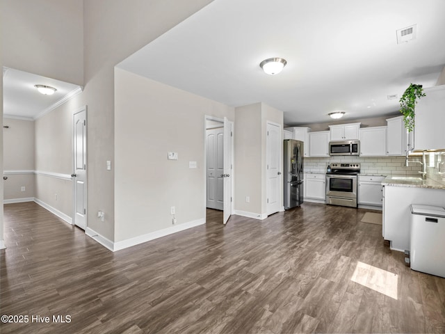 kitchen with a sink, stainless steel appliances, backsplash, baseboards, and visible vents