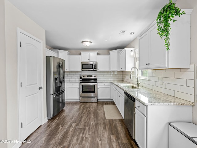 kitchen with stainless steel appliances, visible vents, a sink, light stone countertops, and white cabinetry
