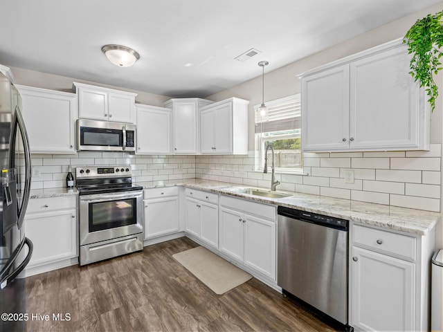 kitchen featuring visible vents, white cabinetry, stainless steel appliances, and a sink