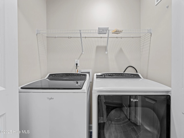 washroom with washing machine and clothes dryer and laundry area