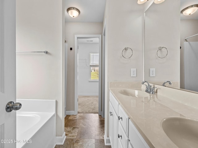 bathroom with double vanity, a bath, baseboards, and a sink