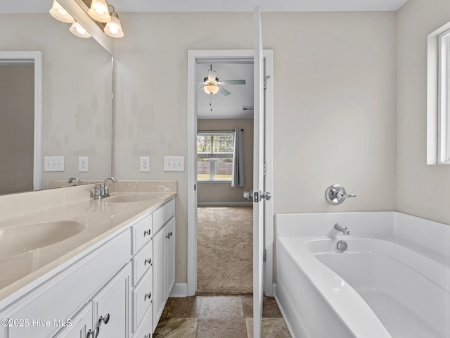 bathroom featuring a bath, double vanity, baseboards, and a sink