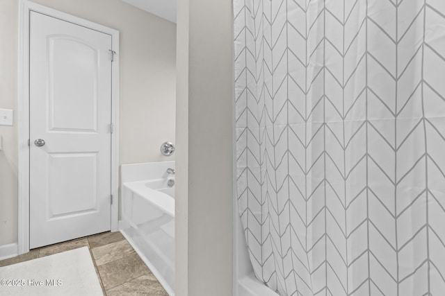 bathroom featuring a washtub, baseboards, and a shower with curtain