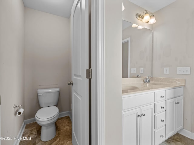 bathroom featuring tile patterned flooring, baseboards, toilet, and vanity