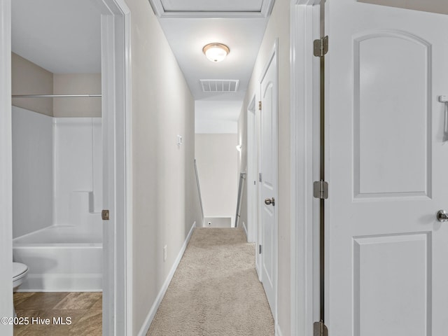 hall featuring baseboards, carpet flooring, and visible vents