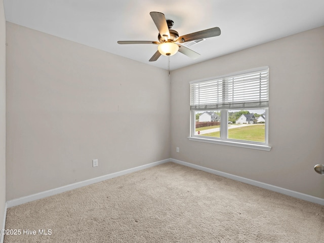 empty room with baseboards, a ceiling fan, and carpet