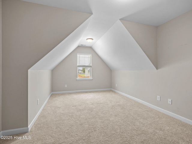 additional living space featuring vaulted ceiling, baseboards, and carpet