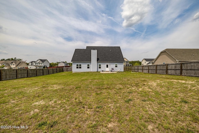 back of property featuring a fenced backyard and a yard