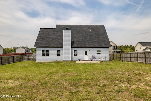 back of house with a yard, a patio area, roof with shingles, and a fenced backyard