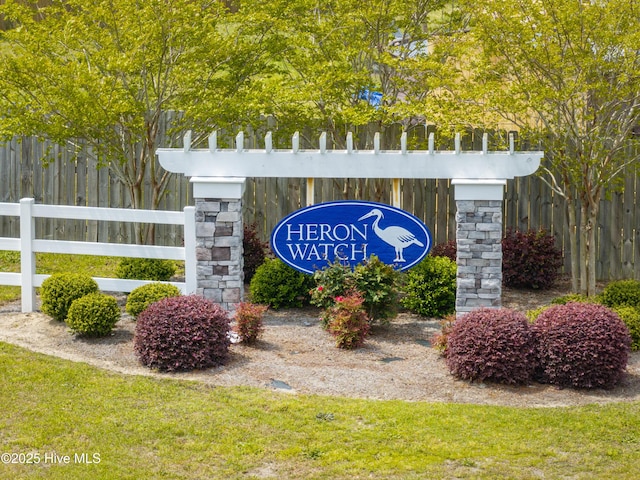 community / neighborhood sign featuring fence