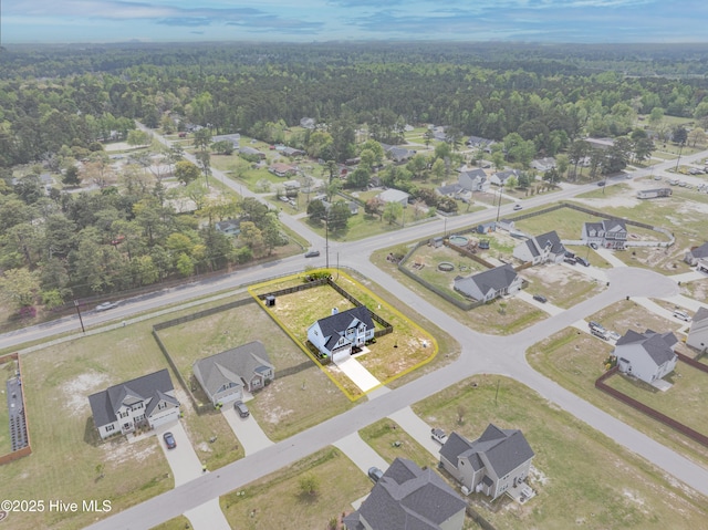 drone / aerial view featuring a view of trees and a residential view